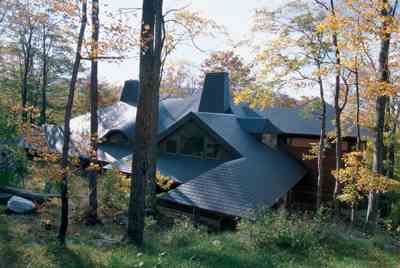 
The slate roof blends quietly with the wooded landscape and echoes the gentle surrounding ridges. In winter, its downslope orientation allows for a camouflage of snow.
